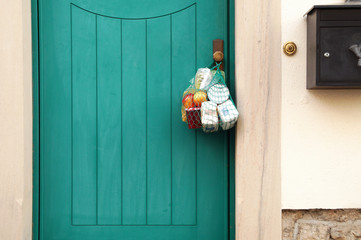 delivery during the quarantine. Shopping bag with Merchandise, goods and food is hanging at the...