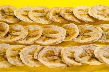 Dried banana chips, sliced in thin circles. Background for healthy and natural nutrition.