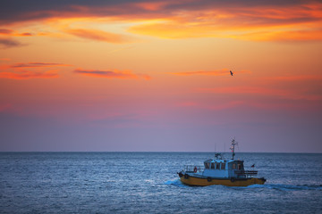 Patrol boat sailing at sunrise in sea water