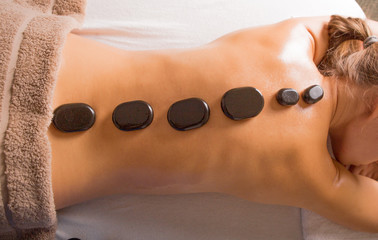 Top view of mature woman relaxing during hot stone massage