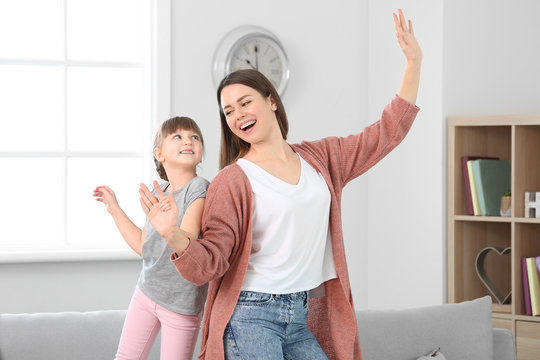 Happy Mother And Her Little Daughter Dancing At Home