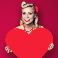 Woman holding paper heart shape. Pin up girl. Retro fashion and vintage. Copy space for some text....