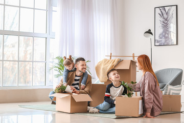 Family unpacking moving boxes in their new house