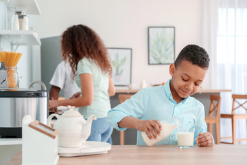 African-American boy drinking milk in kitchen
