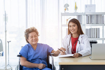 Fototapeta premium Young attractive Asian doctor is cheering her patient up about her symptoms, healtcare and hospital concept.