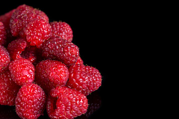 Fresh raspberries close up on a black background. Selective focus
