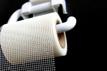 Plan B or alternatives concept. Wrong choice. A roll of white mesh looks like toilet paper. Black background.