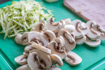 Geschnittene Pilze und Zucchini auf Schneidebrett - Gesundes Essen