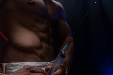 Bodybuilder holding big syringe with injection. concept of steroid in the sport and addiction 