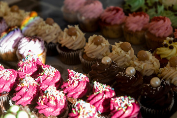 Muffins and cupcakes behind the glass in a cafe.