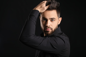 Handsome man with healthy hair on dark background