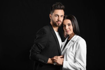 Young couple with beautiful healthy hair on dark background