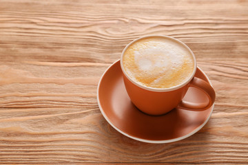 Cup of hot coffee on wooden table