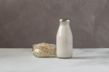 Zero waste and eco friendly food concept:gluten free Oat milk in glass bottle and oat flakes in a jar.