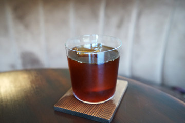 Close up glass of iced black Americano coffee on wooden tray table