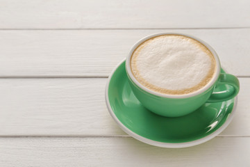 Cup of hot coffee on wooden table