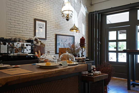 Interior design and decoration of local coffee bar and bakery pastry shop decorated with wooden antique furniture and white brickwall