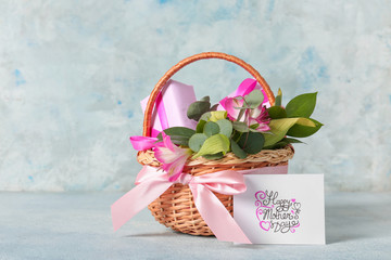 Basket with gifts for Mother's Day on color background