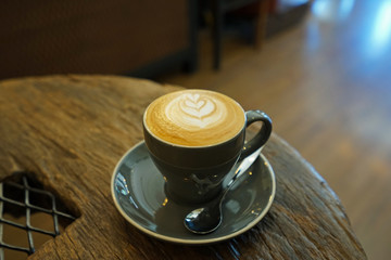 Close up ceramic cup of hot Latte coffee on wooden table