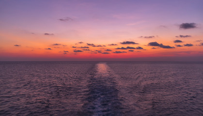 Fototapeta na wymiar Open sea travel by ferry. Enjoying impressive vivid sunset from a boat while on boat in Indonesian waters, Java sea near near Sulawesi and Kalimantan. Exploring the sea