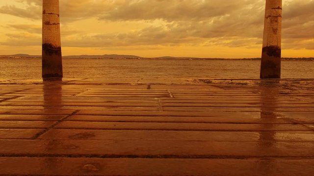 Amazing slow motion sunset shot of the Tagus River and the Cais das Colunas Pier in Lisbon, Portugal, the grand gateway into the capital from the sea