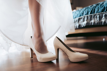 bride's feet in white wedding shoes