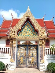 Fototapeta na wymiar Buddhist temple entrance gate of church isolated on blue sky background closeup.