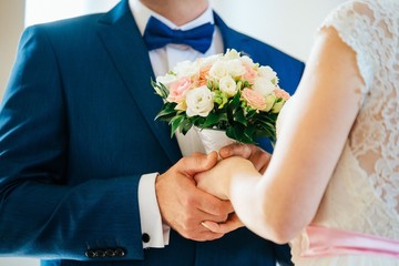 Obraz na płótnie Canvas wedding bouquet in hands of bride and groom