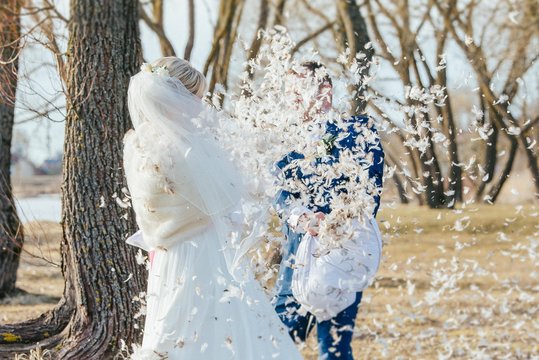 Bride And Groom In White Pillow Fight Outdoor