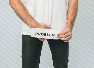Young man isolated over background. Guy wants to pee but can't. Urinal disease. Suffer from pain...