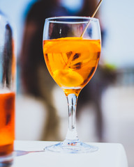 Glass of Aperol Spritz cocktail in a sunny setting with a blue sky