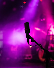 Microphone on stage with purple violet lights