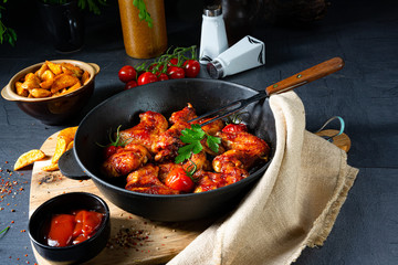 Spicy chicken wings in honey with potato wedges