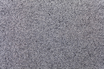 Silver sparkling background from small sequins, closeup. Gray metallic paper backdrop from foil.