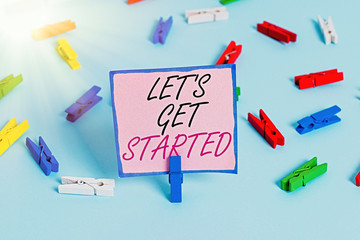 Word writing text Lets Is Get Started. Business photo showcasing to begin doing or working on something you had started Colored clothespin papers empty reminder blue floor background office pin