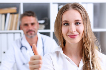 Woman show OK or confirm with thumb up at doctor office portrait. High level work, confident satisfied client do like, visit, best occupation, healthy life, emergency help, teamwork success concept