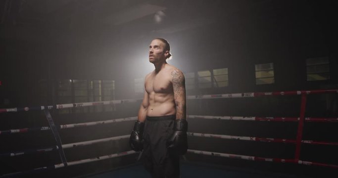 Male shadow boxing in dark gym