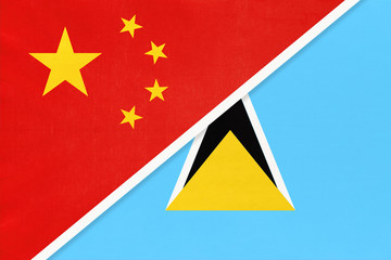 China or PRC vs Saint Lucia national flag from textile. Relationship between asian and american countries.