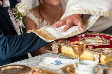 Bride and Groom hands on bible with flowers