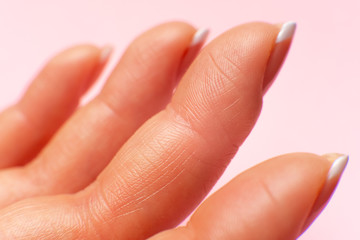 the inner surface of female fingers on a pink background. fingertips