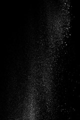White fluffy snow on small particles isolated on black background