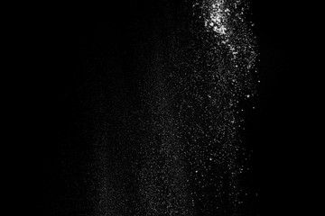 Fototapeta na wymiar White fluffy snow on small particles isolated on black background