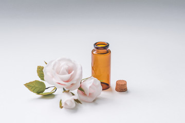 Artfully made artificial white rose in a dark glass vase on a white background