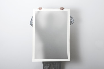 man holding poster representing his shadow, surreal concept