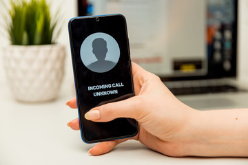 Unknown caller. A man holds a phone in his hand and thinks to end the call. Incoming from an...