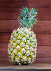 Ripe pineapples on a grey wooden background.