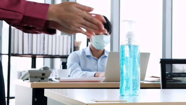 Employee woman using hands sanitizer with alcohol gel to clean for prevent outbreak coronavirus(covid-19) at office.currently virus pandemic .