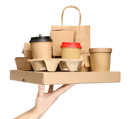 Hand holding various take-out food containers, pizza box, coffee cups in holder and paper bag isolated on white. Food delivery service © Soho A studio