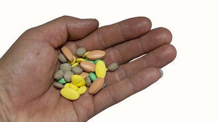 Tablets of various colors in the hand, on a white background