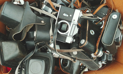 Bunch of old film cameras  put in a cardboard box